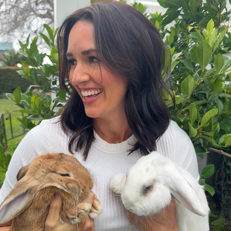SPCA Ambassador Honor Carter holding her two rabbits, smiling