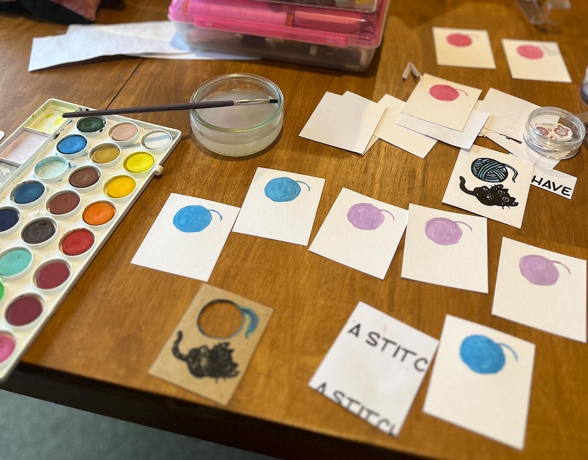 An artist's work table with small prints in progress.