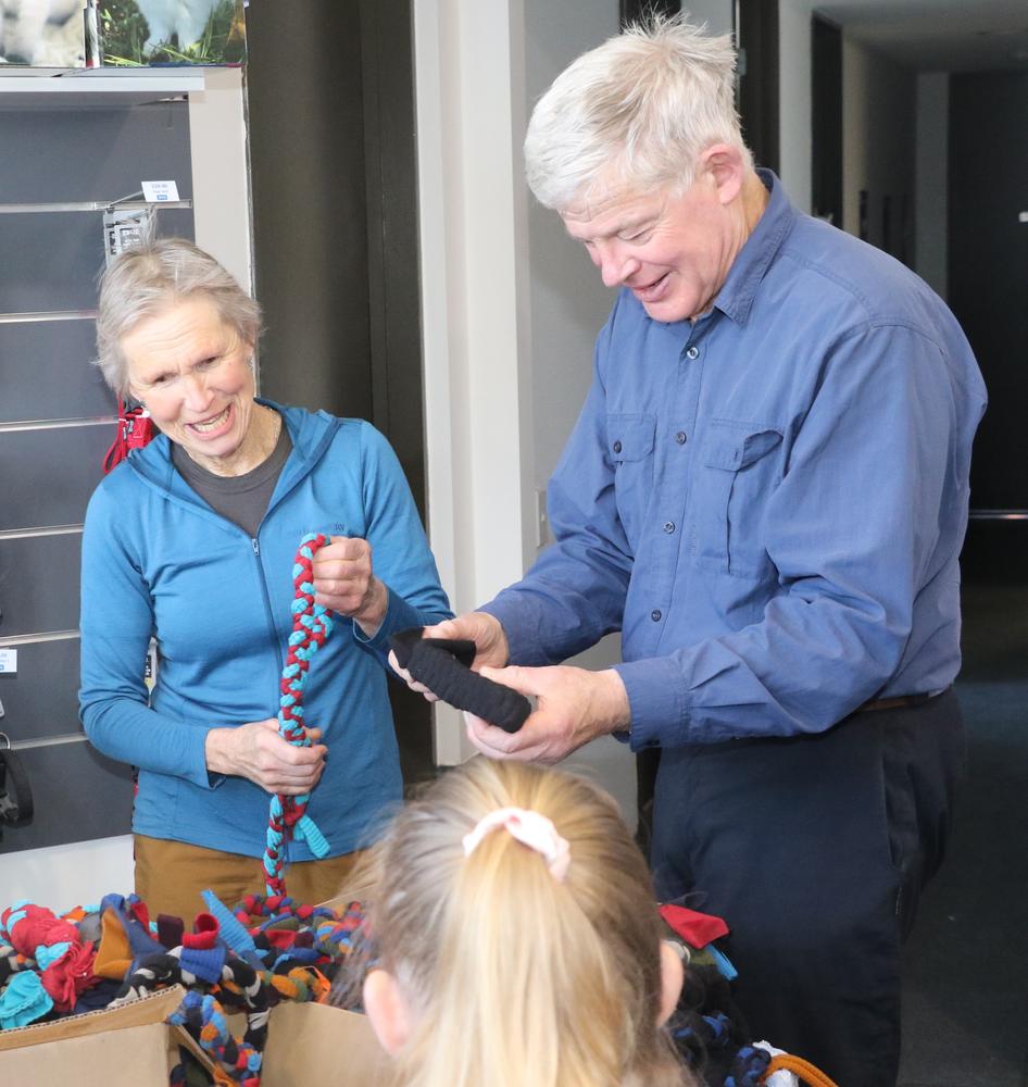 Two older people make toys out of fabric offcuts.