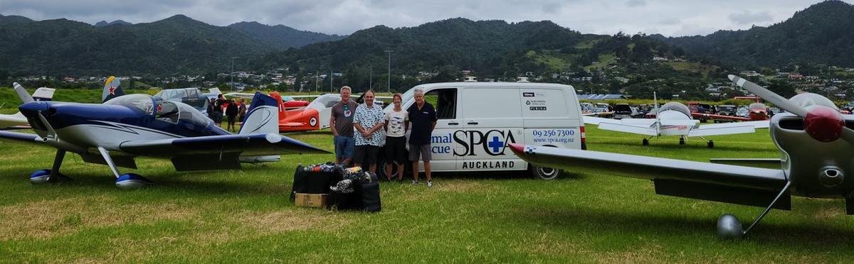 SPCA staff and pilots, alongside aircrafts and the SPCA van.